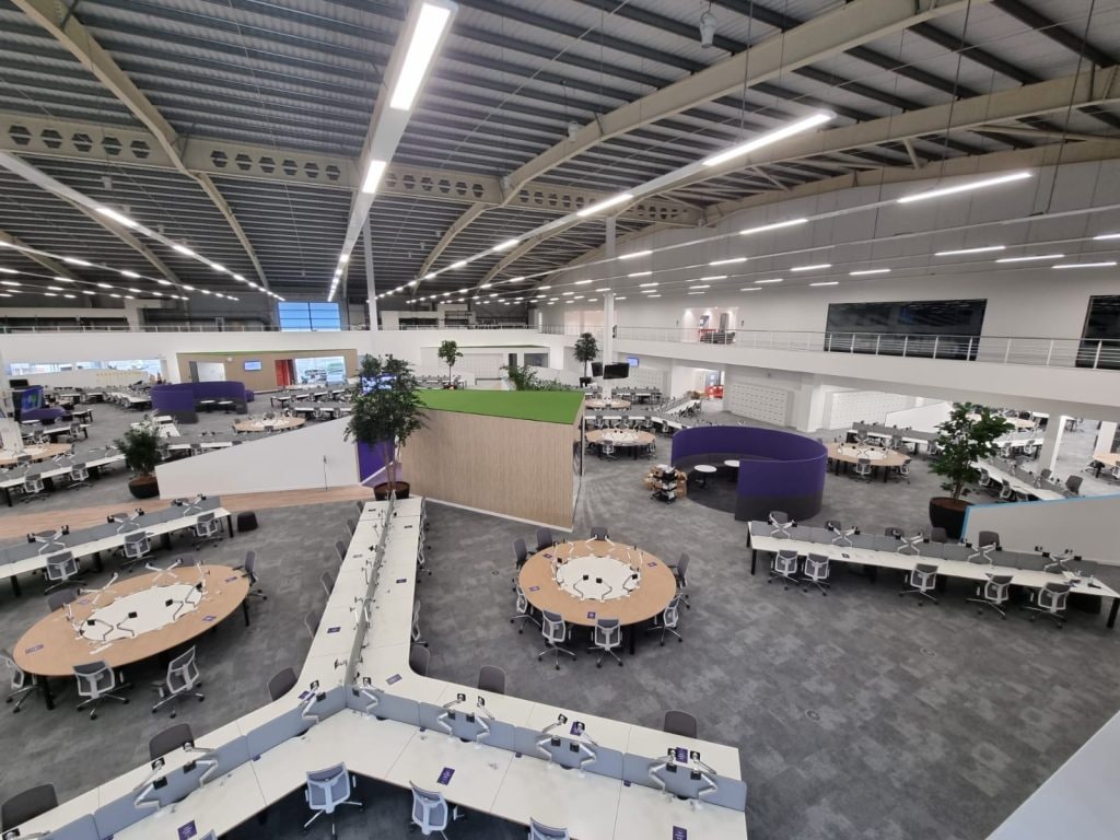 Open-plan call centre floor under a suspended ceiling with linear lighting