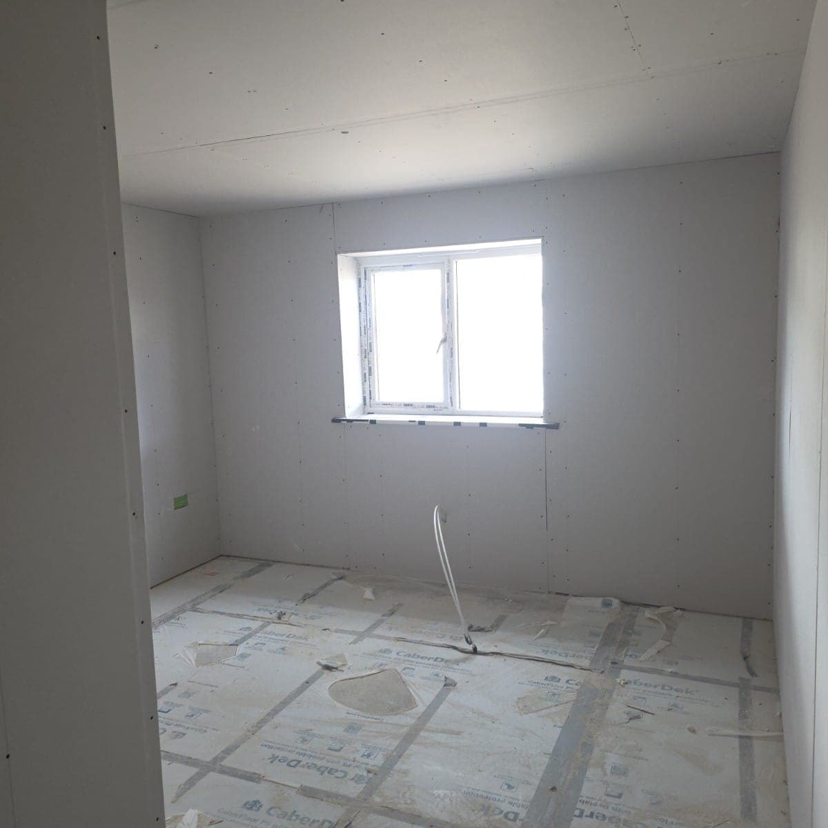Boarded new build bedroom with window reveal formed and floor protection down