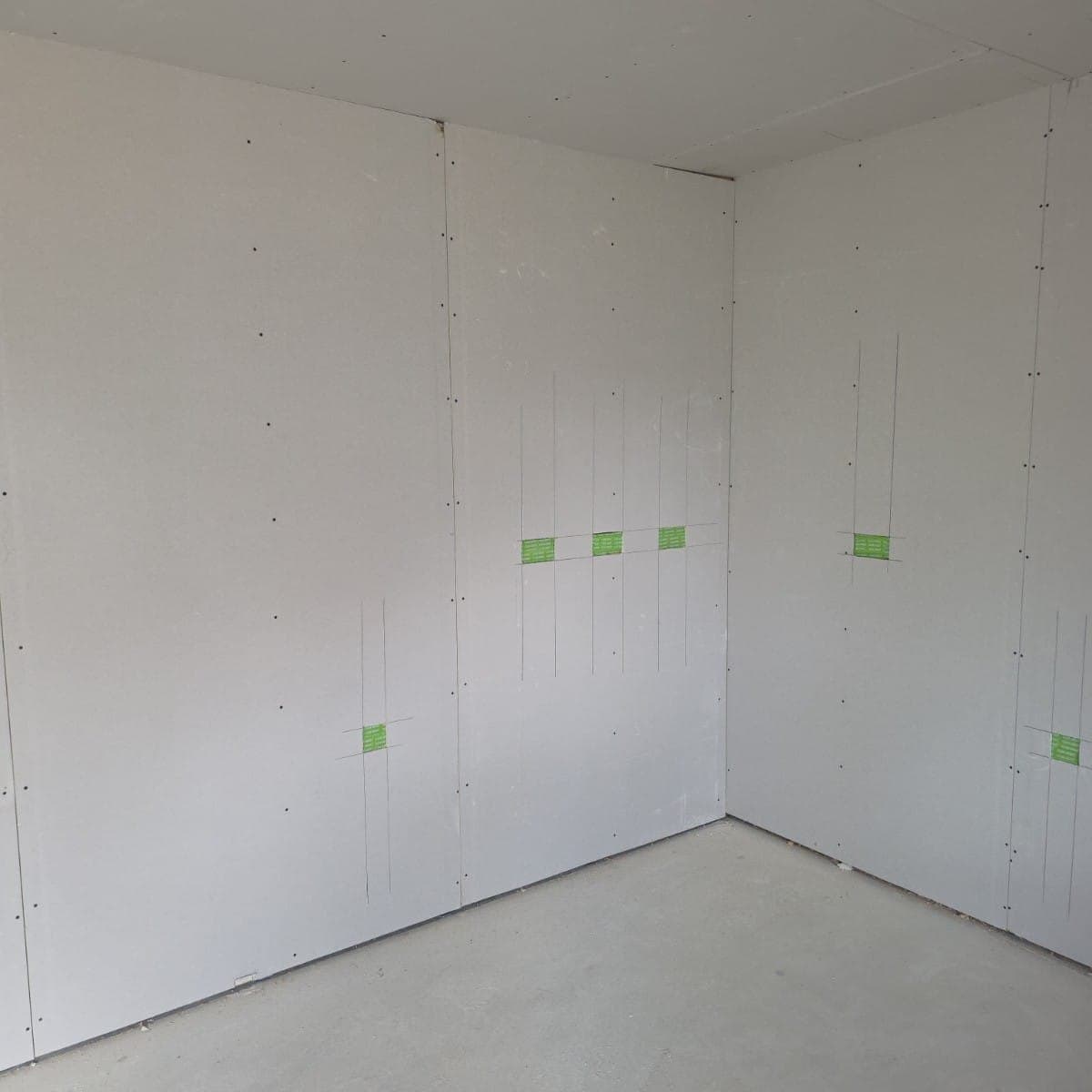 Drylined corner boarded out and screw-fixed, service positions marked up