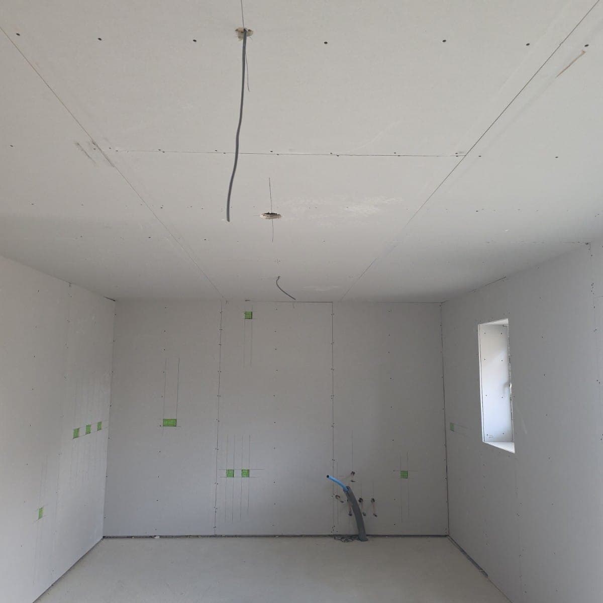 Drylined new build room boarded to walls and ceiling around first fix services