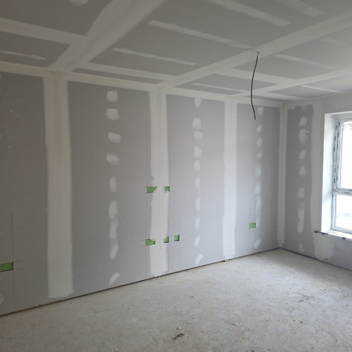 Taped and jointed plasterboard walls and ceiling in a new build room