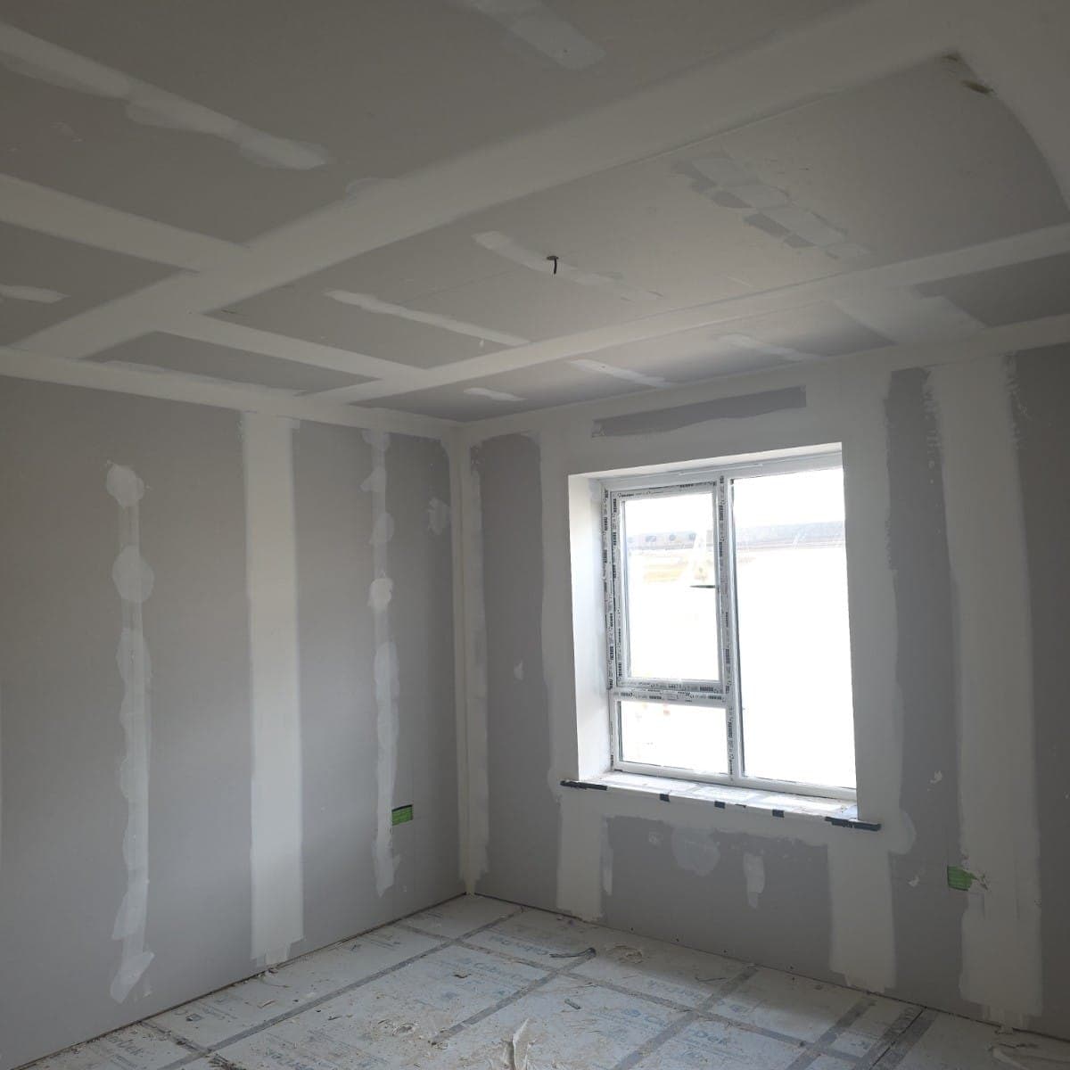 Tape and joint finished around a window reveal in a new build room