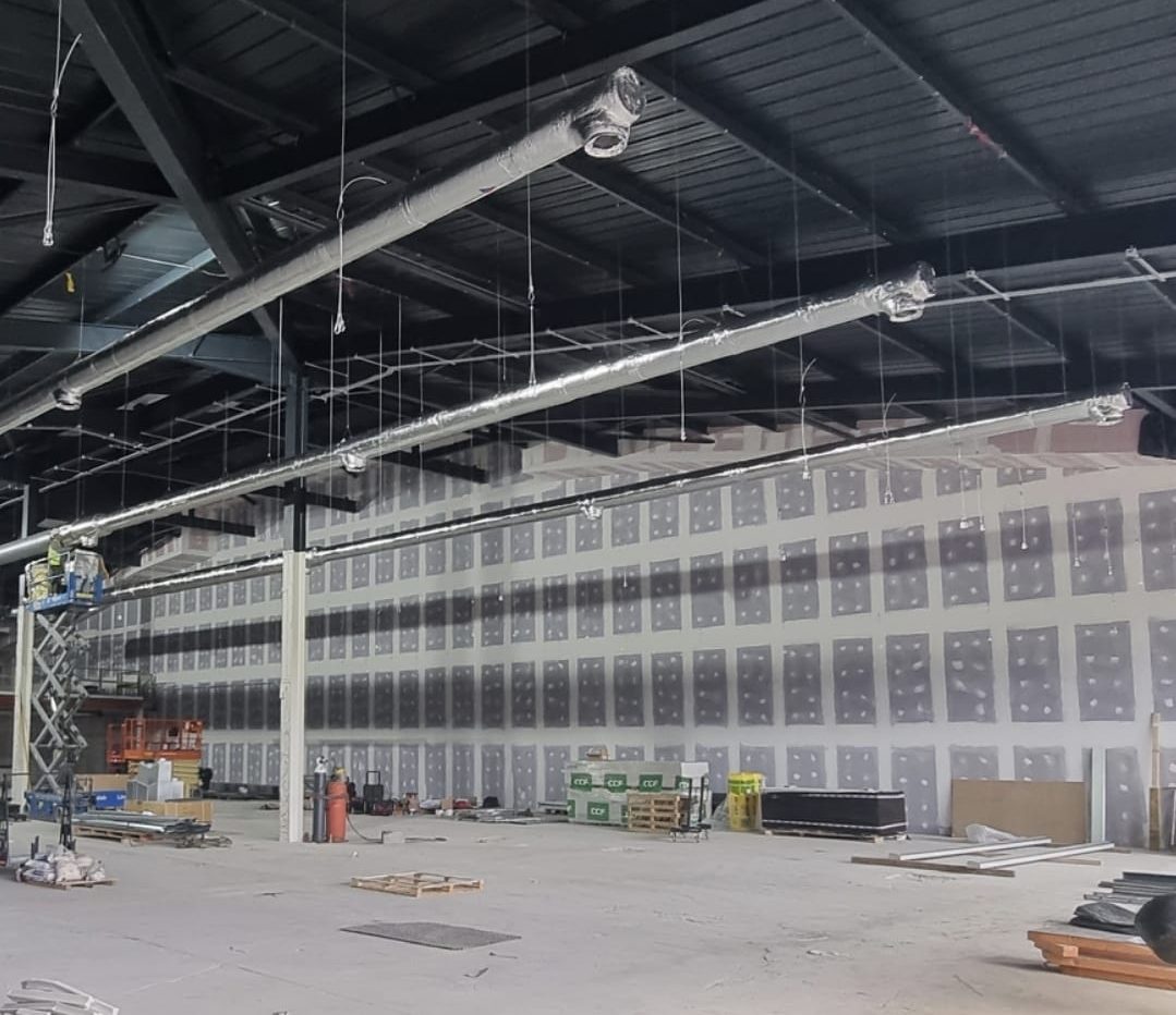 Long partition wall boarded and taped under the roof steels, with services going in overhead