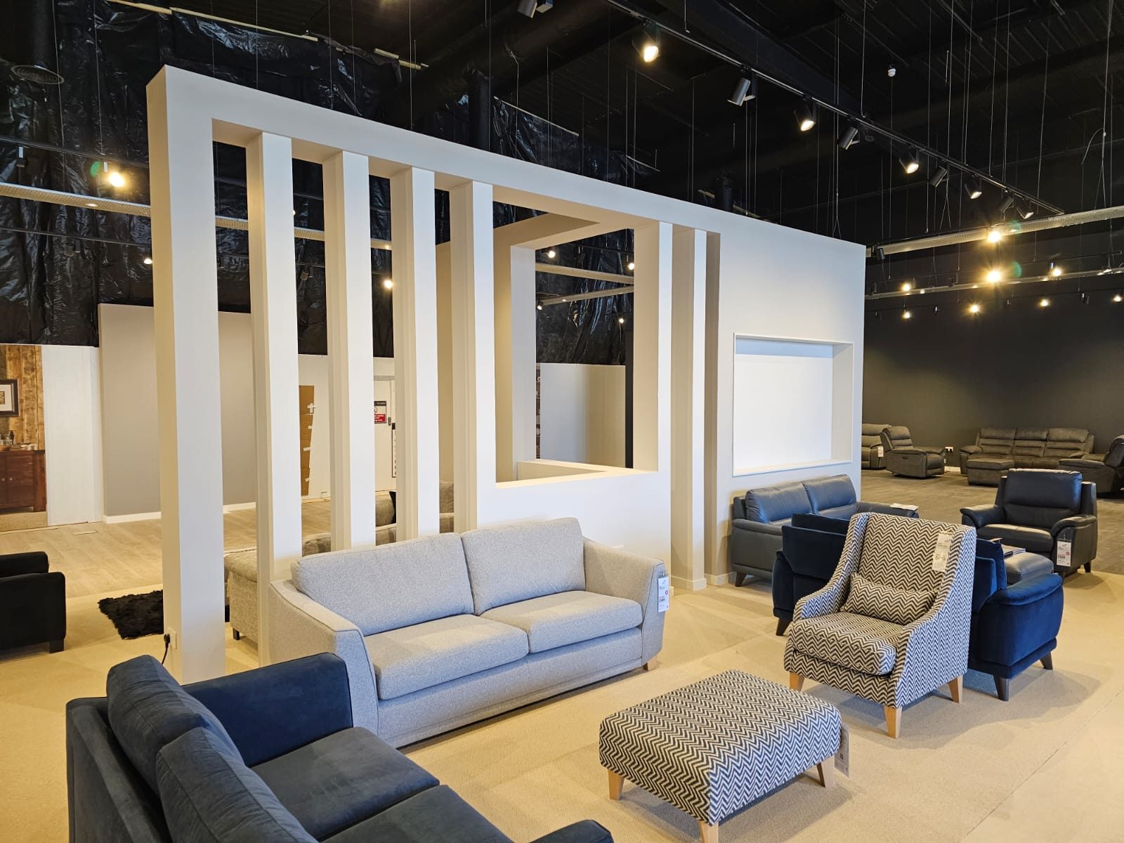 Slatted feature partitions with framed openings forming display bays in a furniture showroom