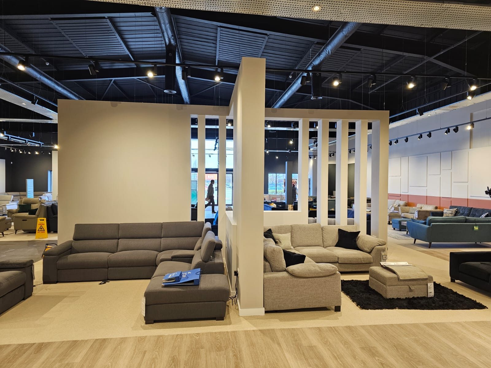 Feature partition with open vertical slats dividing a furniture showroom floor